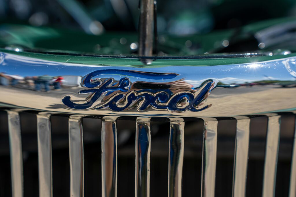 Detailed close-up of a chrome Ford car grille emblem showing reflections, shot in Nelson, Wisconsin.
